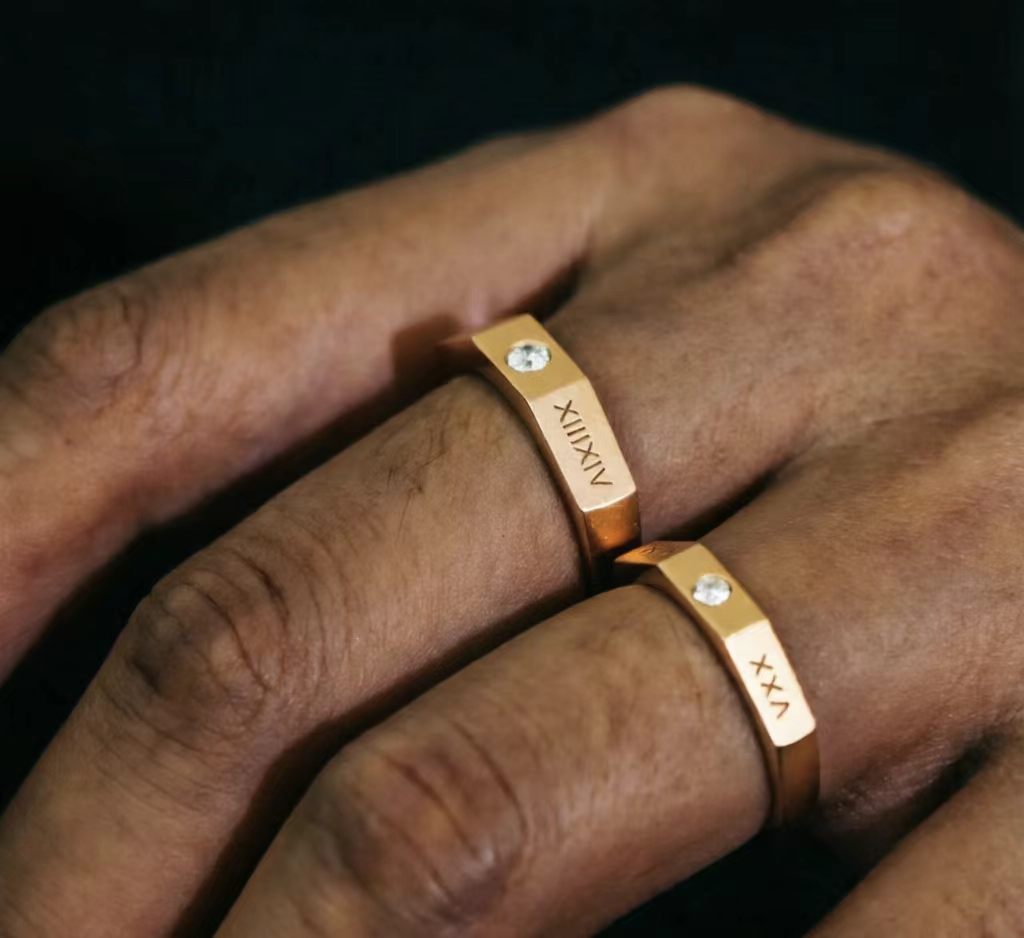 Roman Numeral Couple's Band on couple's fingers